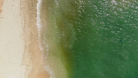 jerusalem beach in kefalonia, greece - awesome beach with emerald green water and small foamy waves rolling onto sandy shore