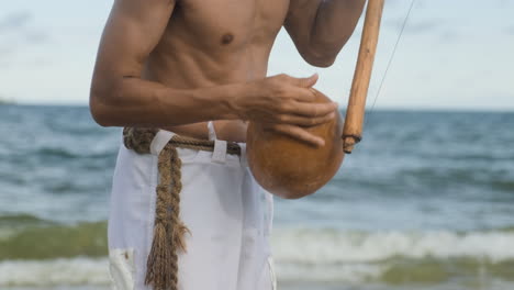 shirtless musician playing instrument