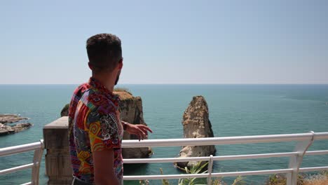 Lebanese-man-showing-the-famous-Pigeon-Rocks-in-Beirut,-Lebanon