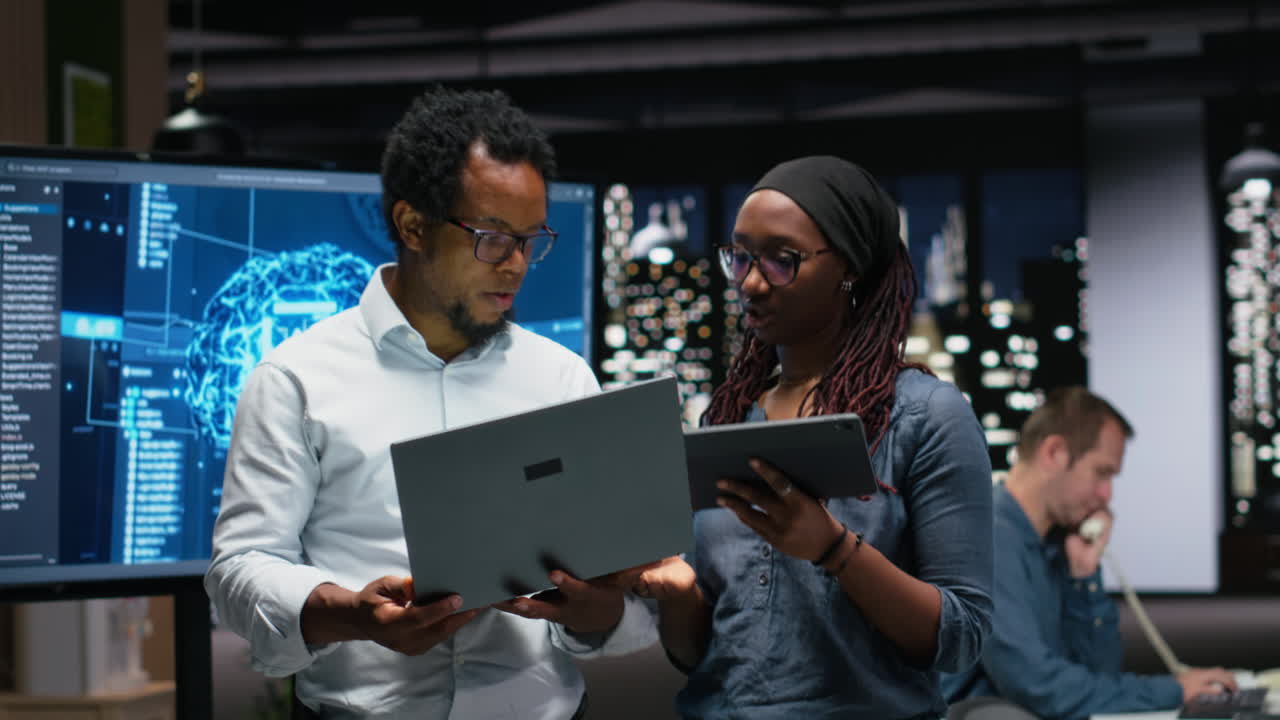African American Colleagues Discussing Data on Laptop and Tablet