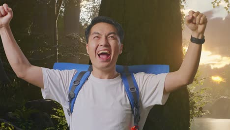산악 등반 배을 들고 있는 아시아 남성 하이커의 근접 사진. 숲의 자연을 탐험하는 동안 성공을 축하하는 목표를 외치고 있습니다.