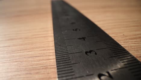 close-up of a metal ruler on a wooden surface