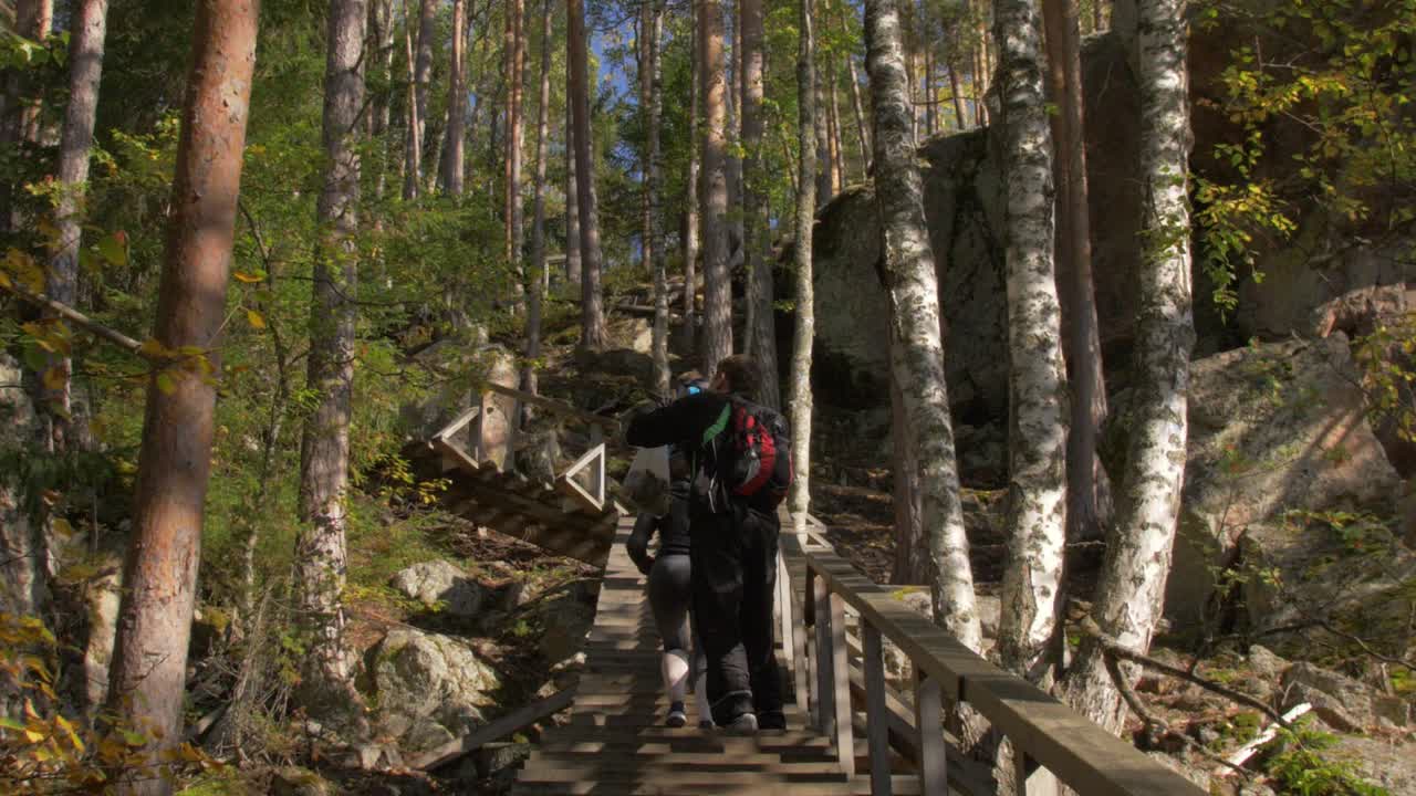 바위가 많은 숲길에서 계단을 오르는 사람들