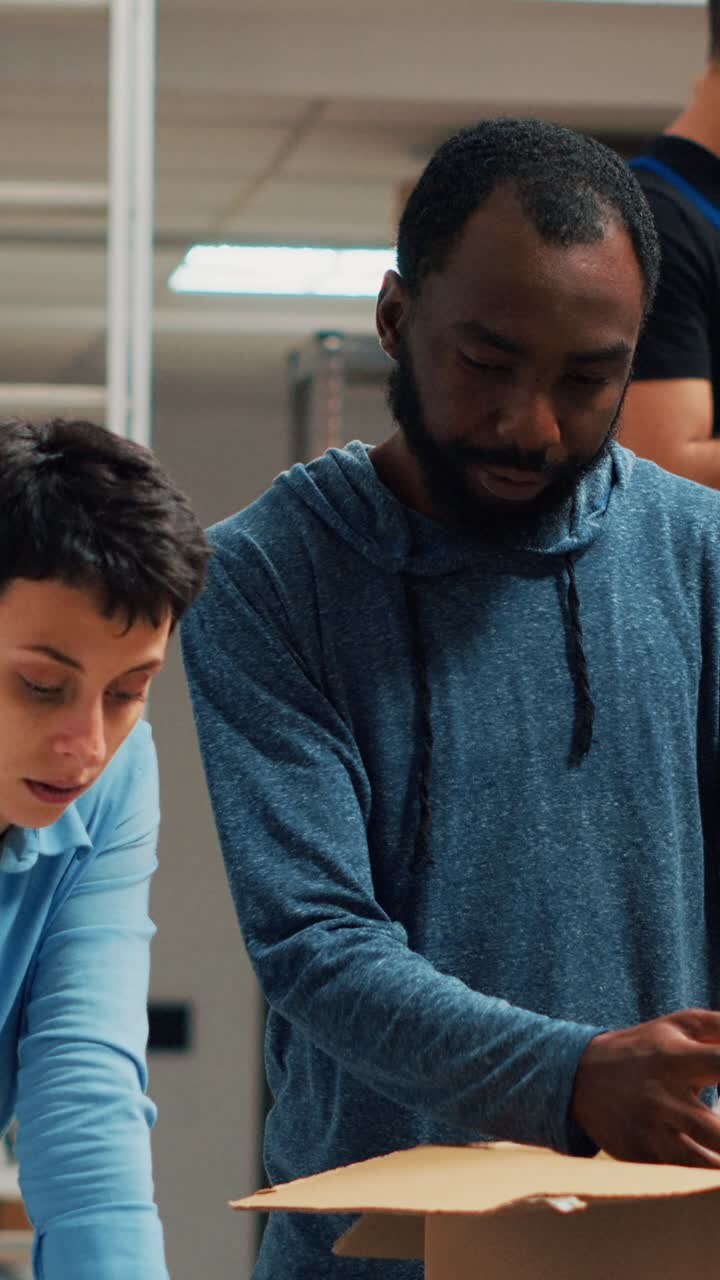 Vertical video: Diverse team of business owners packing order for shipping