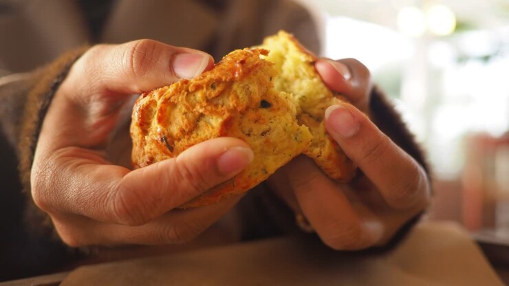 Close-up of Hands Tearing a Freshly Baked Scone