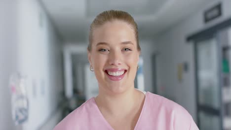 Retrato-De-Una-Feliz-Doctora-Caucásica-Con-Cabello-Rubio,-Sonriendo,-En-Cámara-Lenta