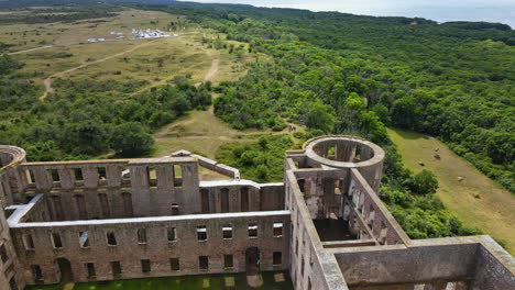 Abra-Las-Paredes-De-Piedra-Caliza-Del-Castillo-De-Borgholm-Situado-En-Un-Paisaje-Verde-Y-Exuberante-Aislado-En-Öland,-Suecia---Drone-Shot-Pan-Derecha