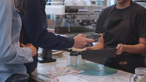 closeup hands of customer man and woman buying coffee and paying together with wallet digital for banking to barista at cafe, scan payment with qr code technology, small business, startup business.