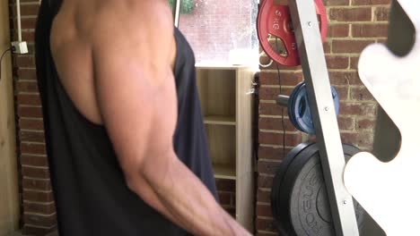 muscly man in home gym exercising bicep curl barbell smith machine