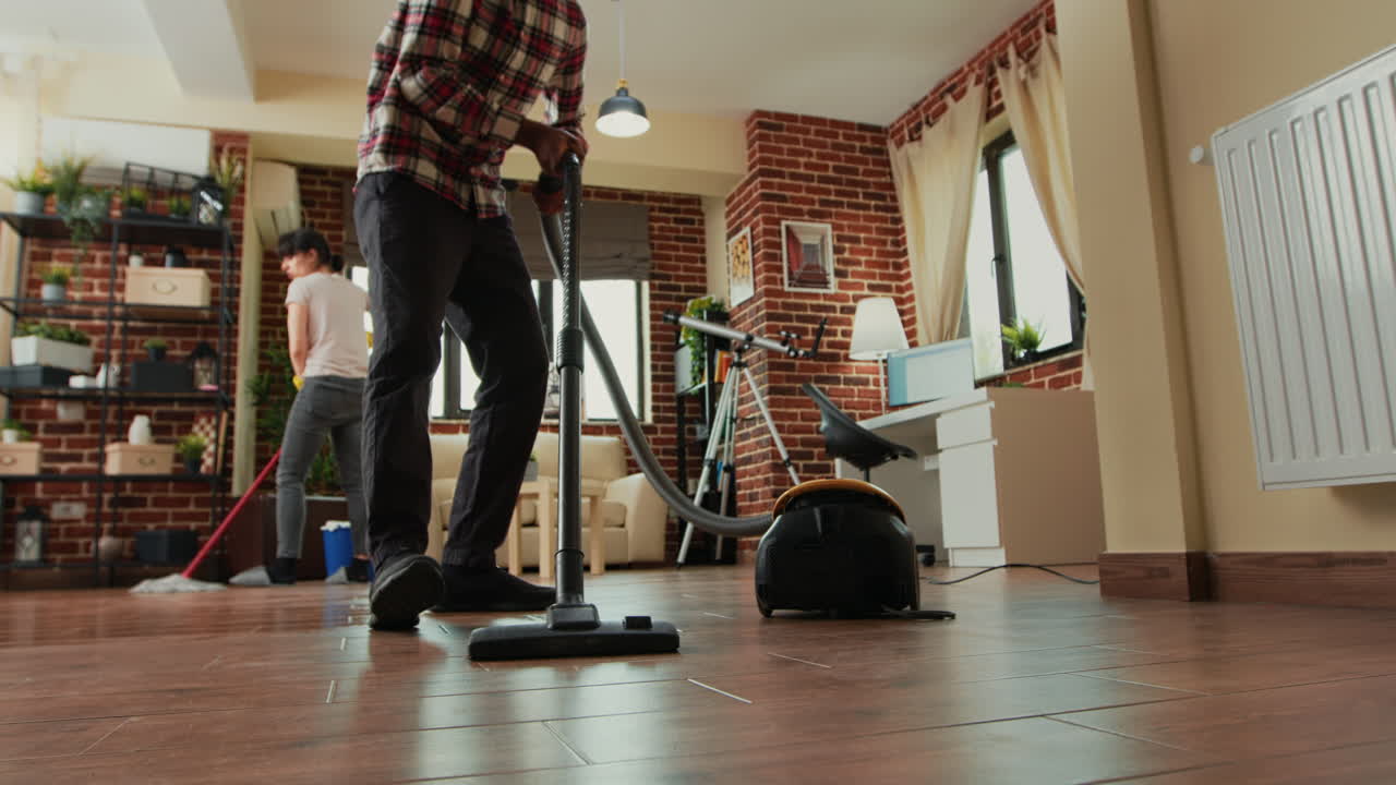 African american man vacuuming floors in living room