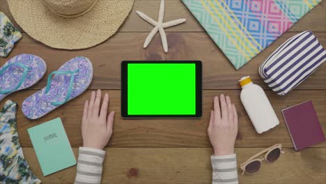 aerial footage of woman touching digital tablet by beach supplies