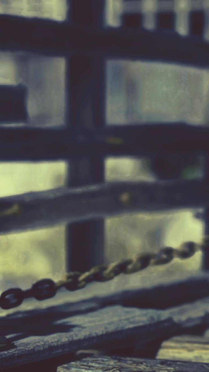 Close view of a chain on a wooden structure during daytime