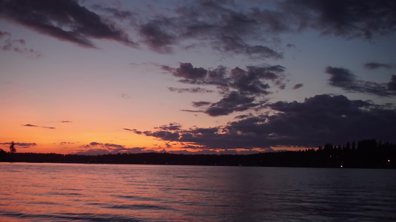Slow zoom out on brilliant sunset sky seen from Fox Island Washington, hyper time lapse