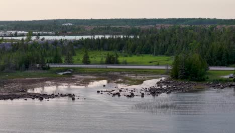 aerial drone footage of a winding river cutting through lush green wetlands surrounded by dense vegetation