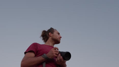 young photographer shooting an outdoor picture, creative guy outdoors, slowmotion shot