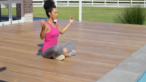 side view of young mixed-race woman doing yoga in backyard of home 4k