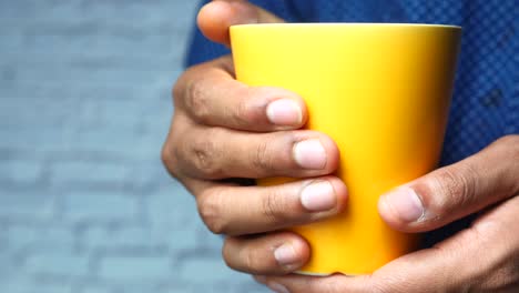 person holding a yellow cup