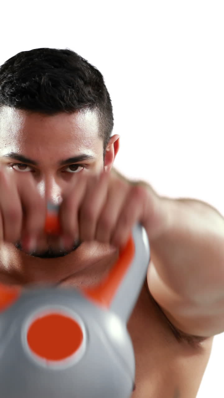 culturista musculoso serio levantando kettlebell