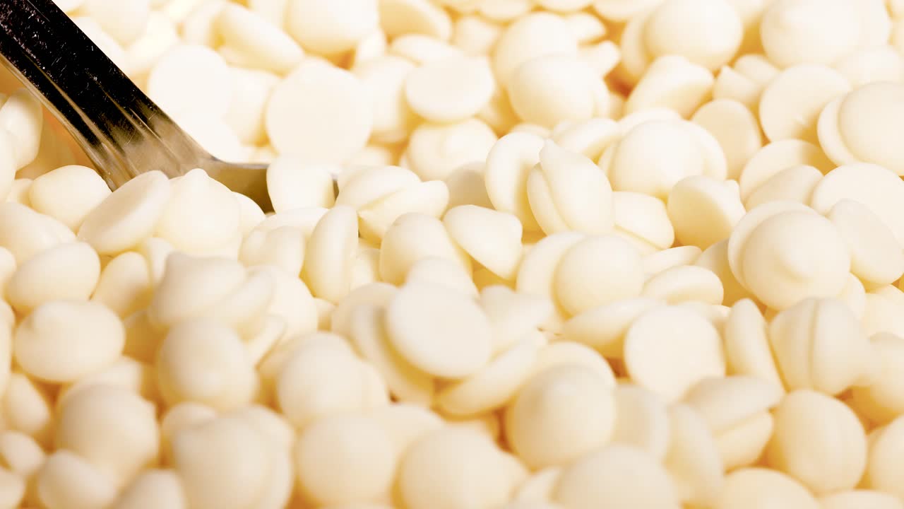 cuchara agitando trozos de chocolate blanco en el tazón