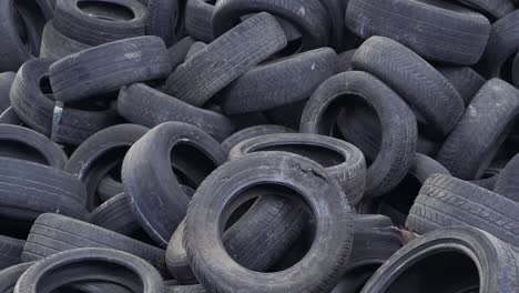 big pile of used black car wheels on the empty territory