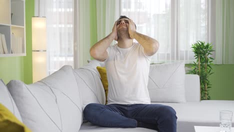 depressed and sad young man is upset at home.