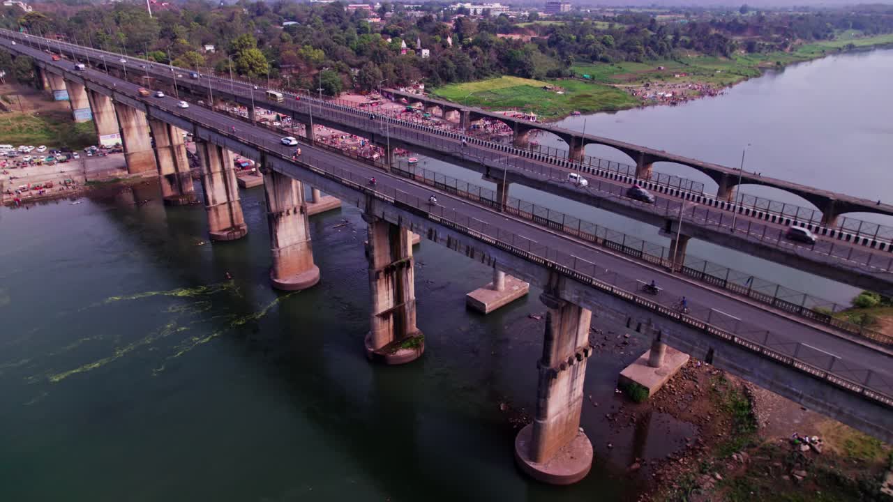 Greenery with Tilwara Narmada River Bridge and Narmada Ghat at Jotpur, Jabalpur, Madhya Pradesh, india. day time, push in, tilt down, drone shot, 4k.