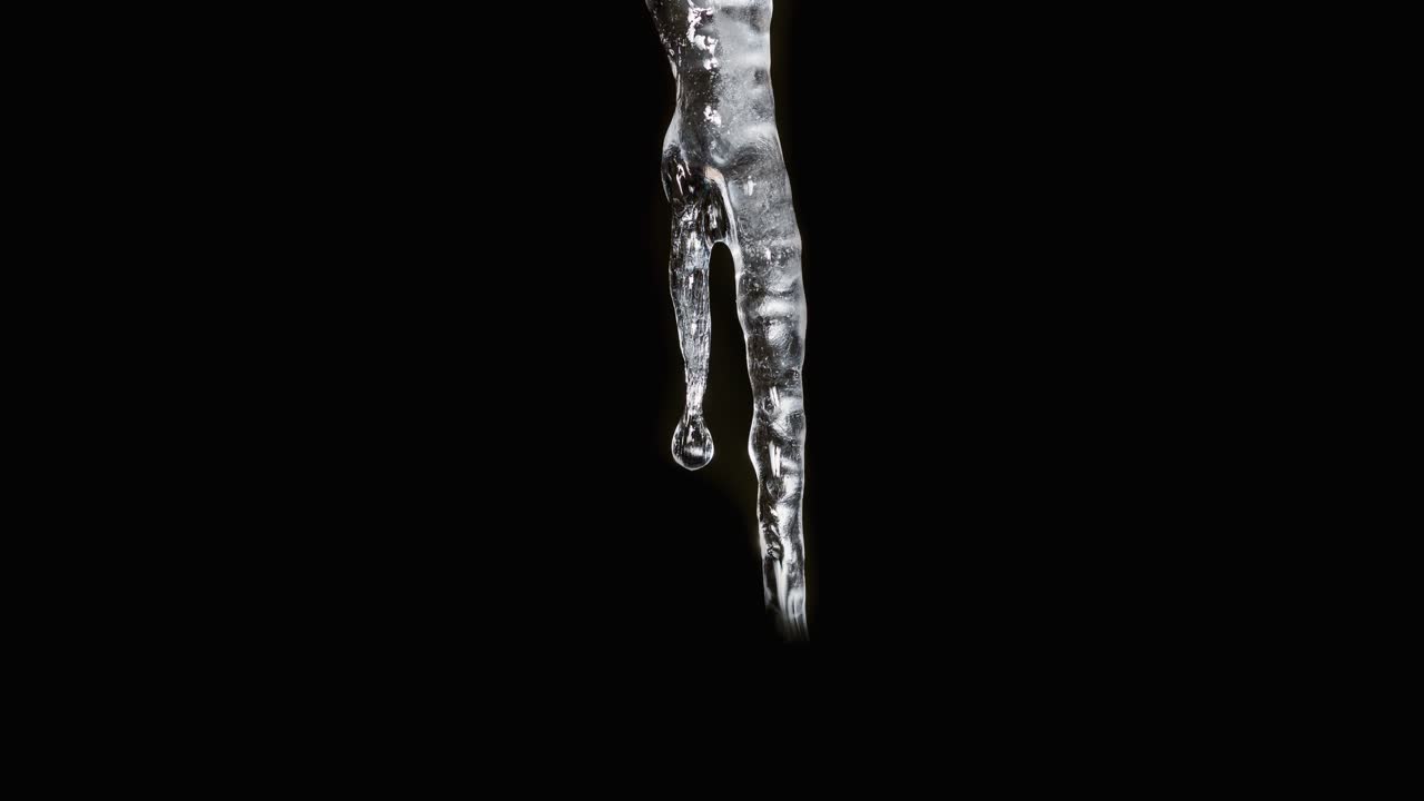 검은 배경 앞에서 자라나는 고드름의 저속 시퀀스