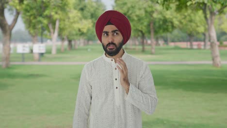 sick sikh indian man suffering from tooth pain in park