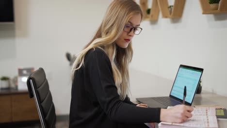 Business-woman-taking-notes-in-her-office