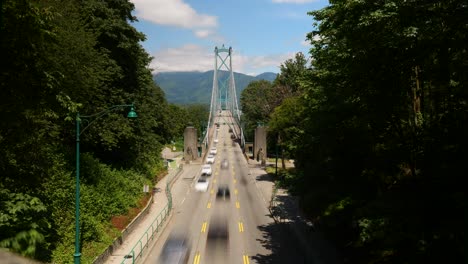 timelapse of the lions gate bridge traffic on a sunny day in stanley park in vancouver city, british columbia, canada