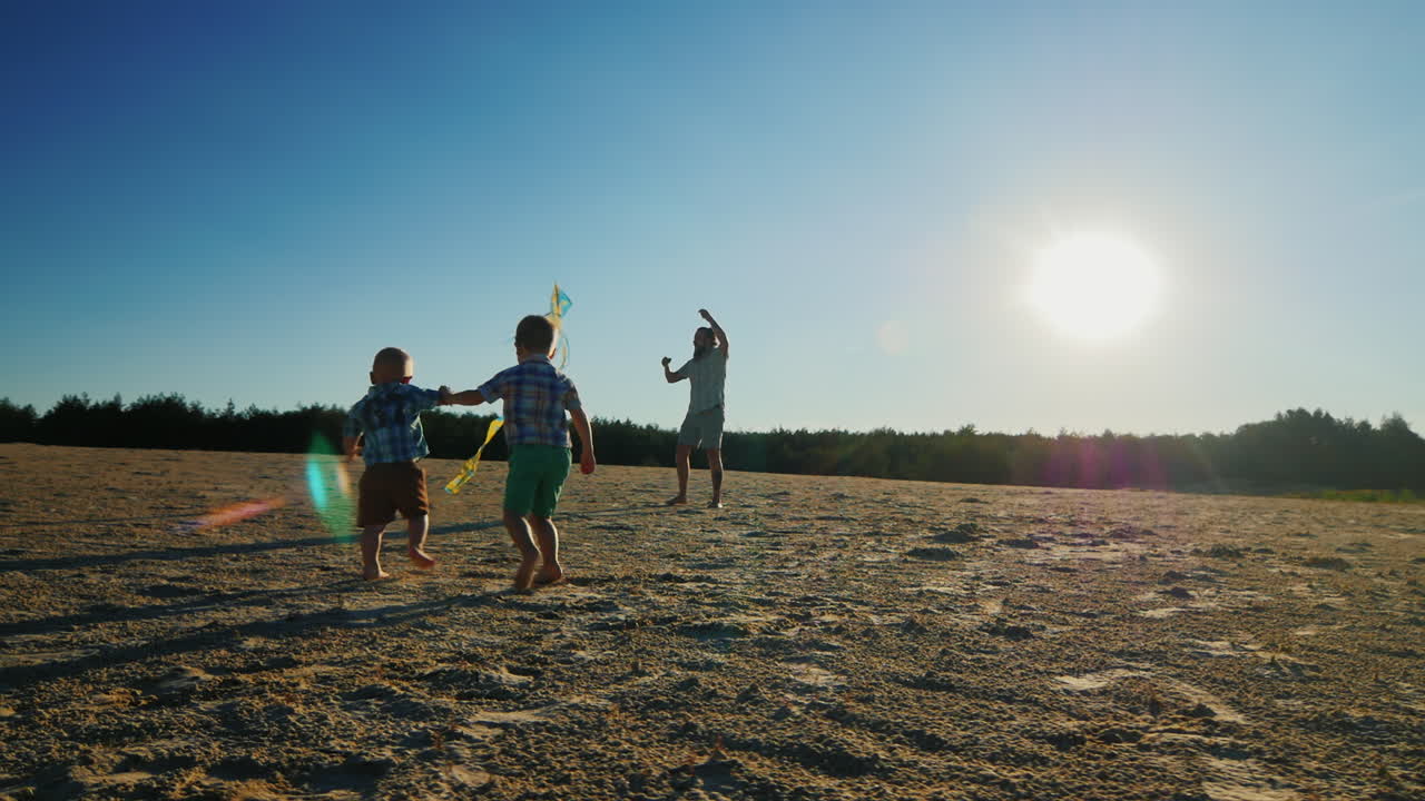 joven padre jugando con sus dos hijos volando una cometa