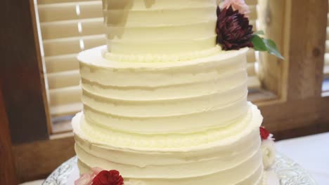 White-vanilla-wedding-cake-set-out-at-wedding-reception