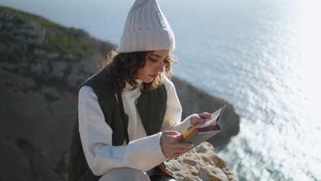 Chica-Tranquila-Disfrutando-De-Un-Libro-En-El-Acantilado-Vertical-Del-Océano.-Montaña-De-Descanso-De-Viajero-Enfocado