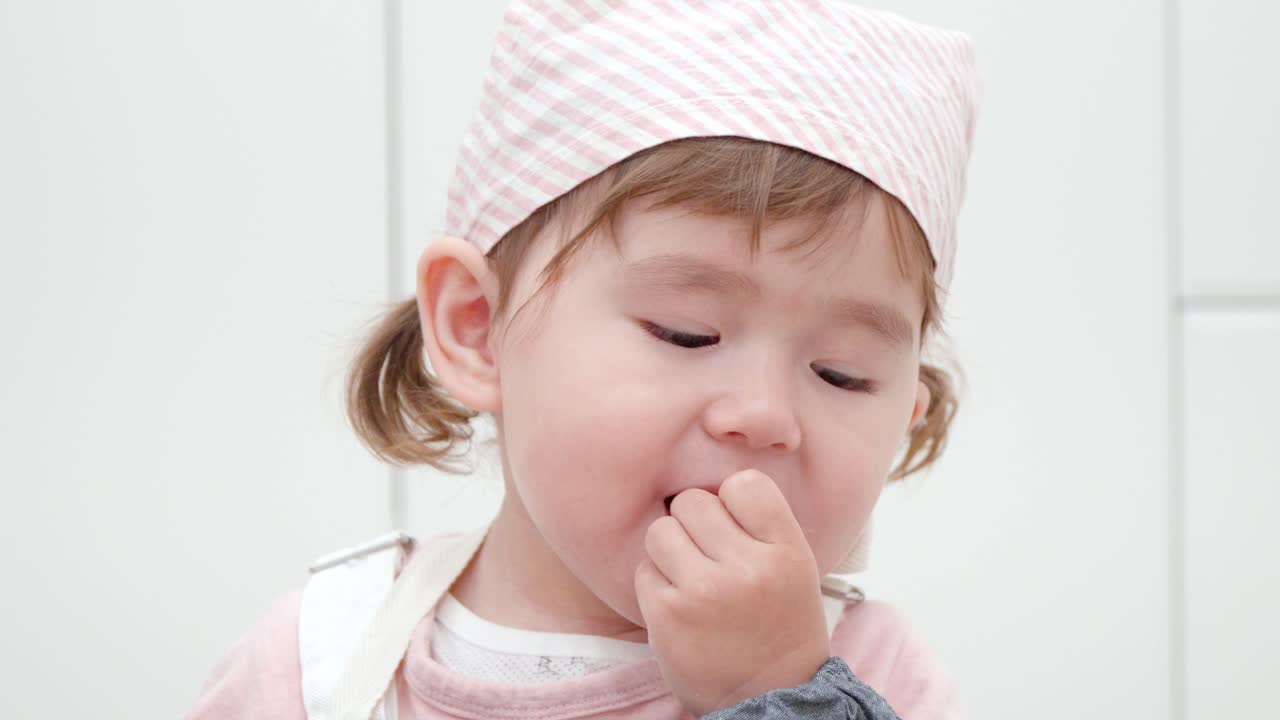 재생하는 동안 비스킷을 먹는 사랑스러운 유아 소녀