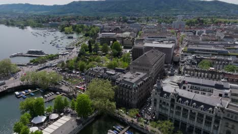 Se-Dejaron-Imágenes-De-Drones-En-Movimiento-Del-Horizonte-De-La-Ciudad-De-Zurich-Y-Frente-Al-Lago-Con-Automóviles,-Transporte-Público,-Barcos-Y-Personas.