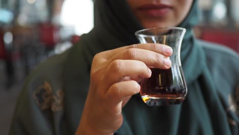 woman in a hijab drinking turkish tea