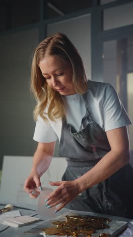 woman artist painting with gold leaf