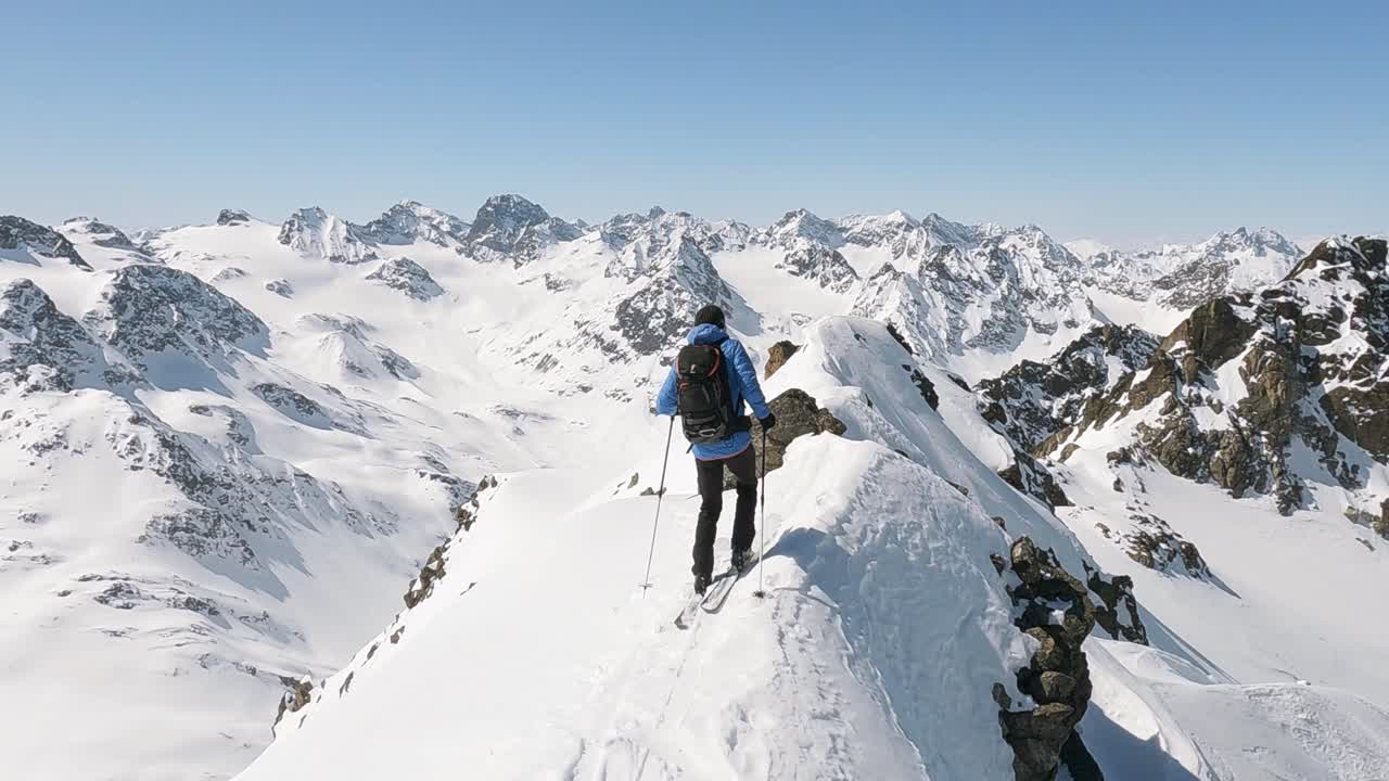 esquiador de freeride masculino esquiando en la cima de una montaña en nieve fresca y profunda fuera de pista