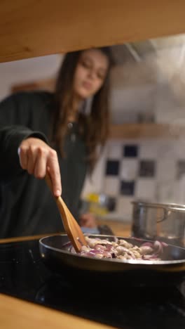 young woman cooking onions