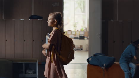 Little-girl-walk-lively-hallway-on-school-break-alone.-Pupil-going-dark-hall.