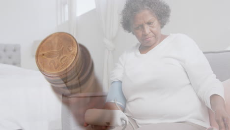 animación de una pila de monedas sobre una mujer mayor preocupada midiendo la presión arterial y sentada en la cama