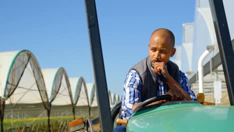 man sitting on tractor in blueberry farm 4k