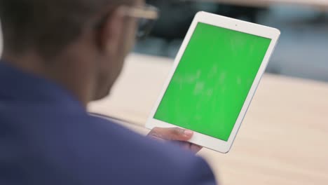 rear view of young businessman using tablet with chroma screen