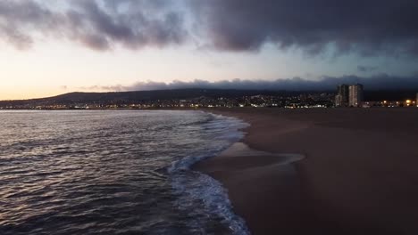 drone flying at the beach during sunset, near the waves