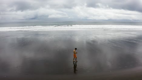 aerial shot of a young man walking on an empty beach, colombia