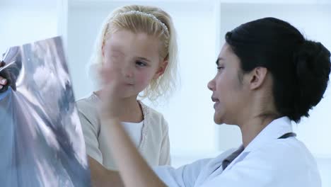 Ethnische-Ärztin-Erklärt-Ihrem-Kleinen-Patienten-Ein-Röntgenbild