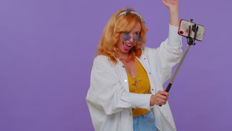 blogger viajera con gafas de sol, tomando selfies en el teléfono móvil, comunicándose por video llamada en línea