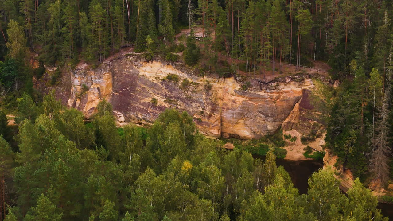 Woodland and cliff outcrop near river, aerial drone view
