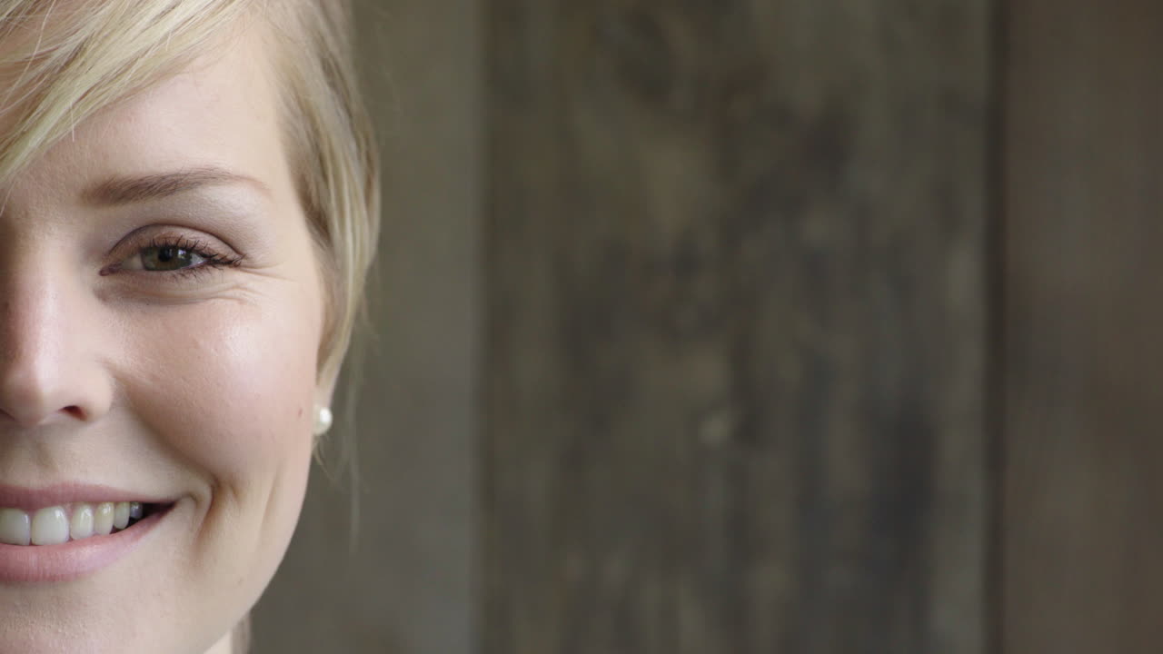 portrait of attractive blonde woman smiling looking at camera caucasian female beauty on wooden background half face