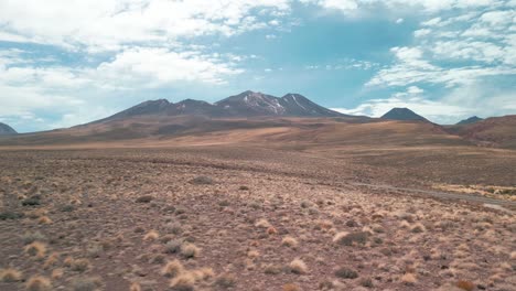 Rodaje-De-Drones-Yendo-A-Un-Volcán-En-El-Desierto-Chileno-Pasando-Cerca-De-La-Vegetación-Seca-Que-Está-En-El-Suelo